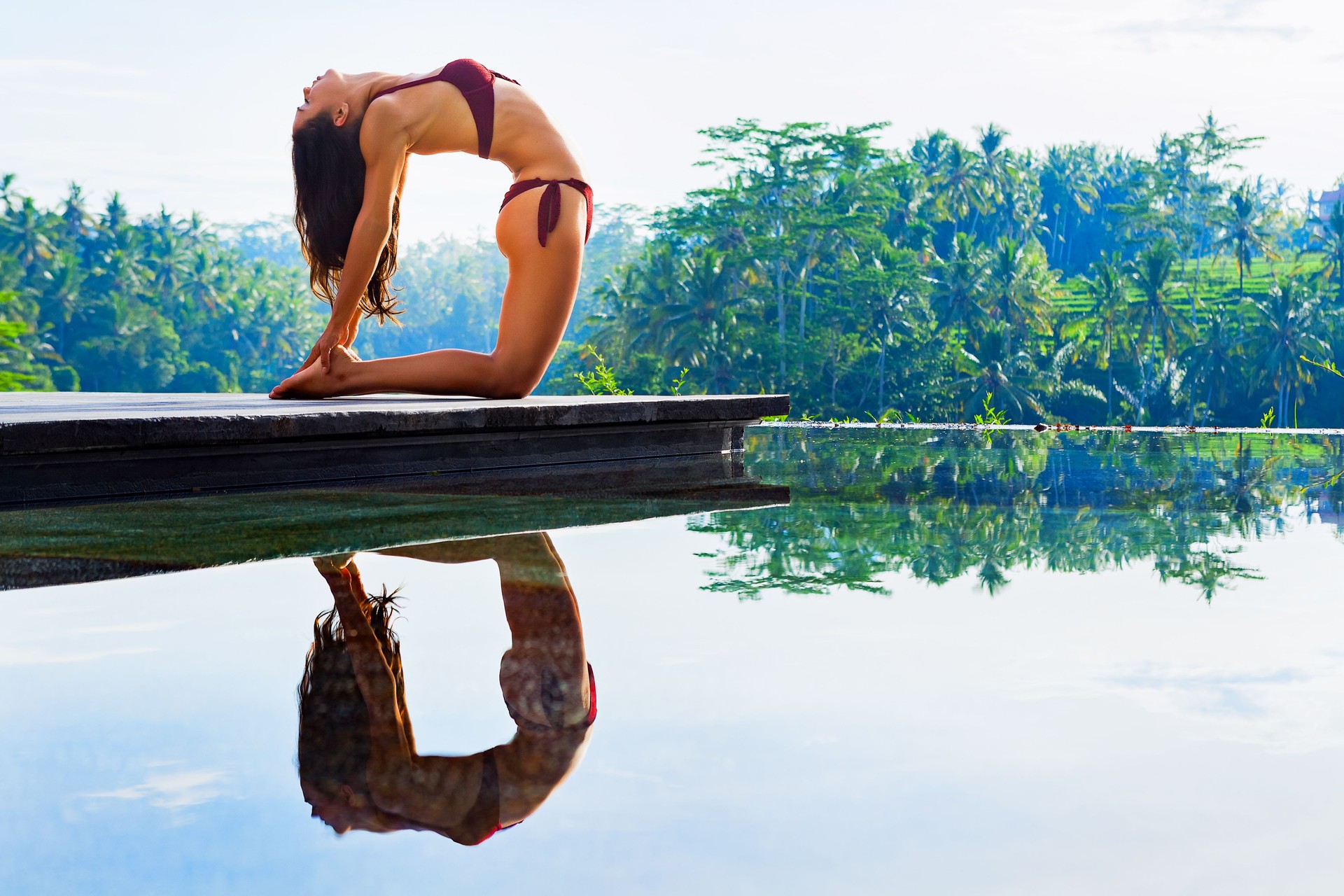 Joven mujer de yoga que se extiende hacia atrás en ustrasana postura de camello
